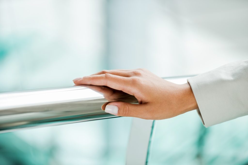 Hand on railing. Close-up of female hand on metal railing