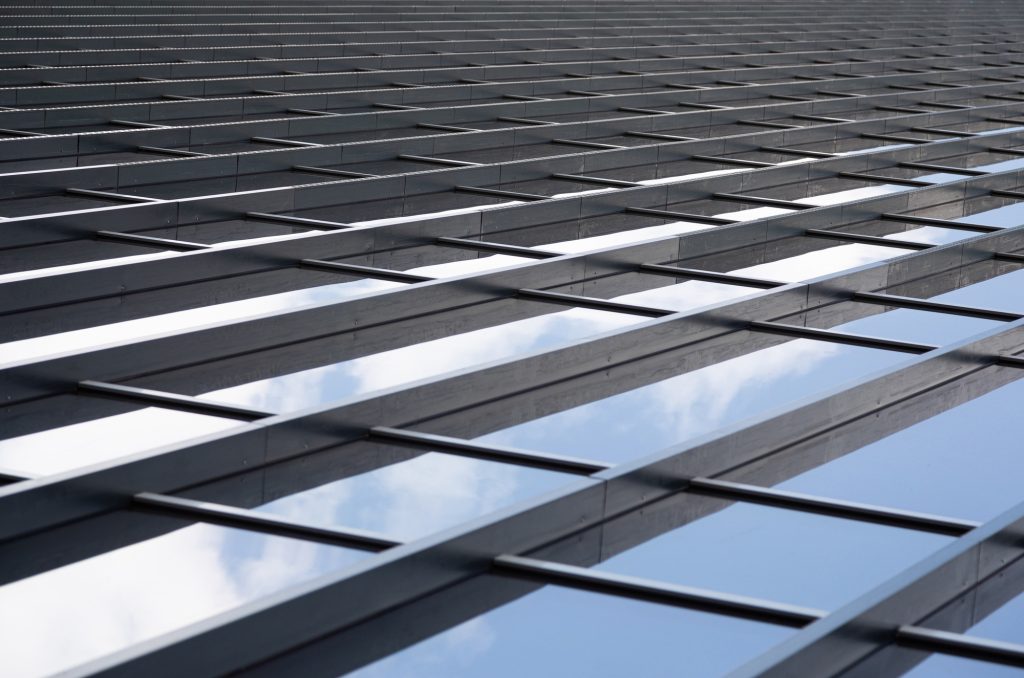Metal girders joining glass panels of a wall